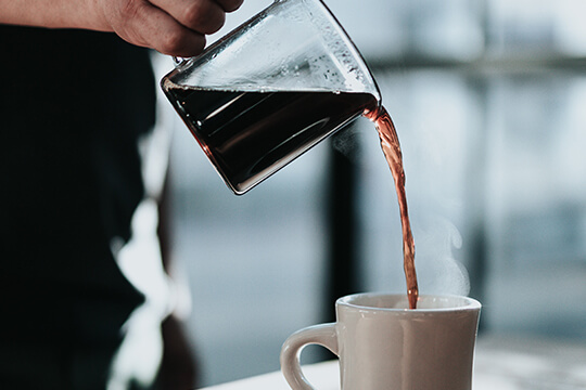 Kaffee wird in Tasse gegossen