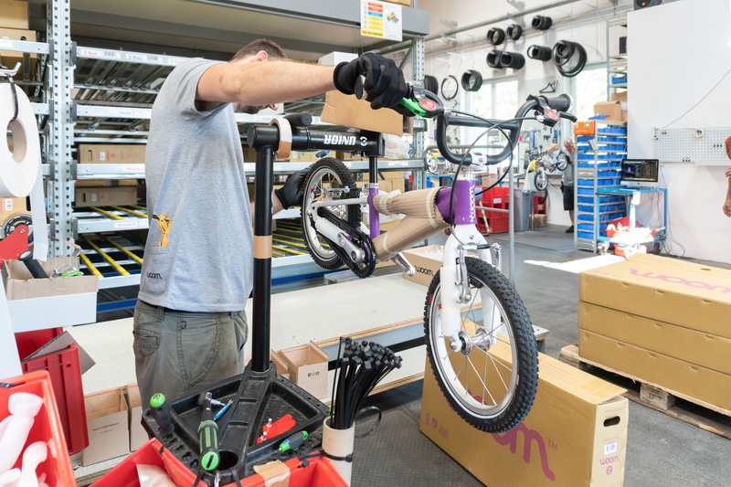 Ein lila woom Kinderfahrrad wird in einer Werkstatt refurbished