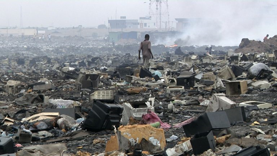 Person walking through e-waste dump. by Unknown Author is licensed under CC BY-SA