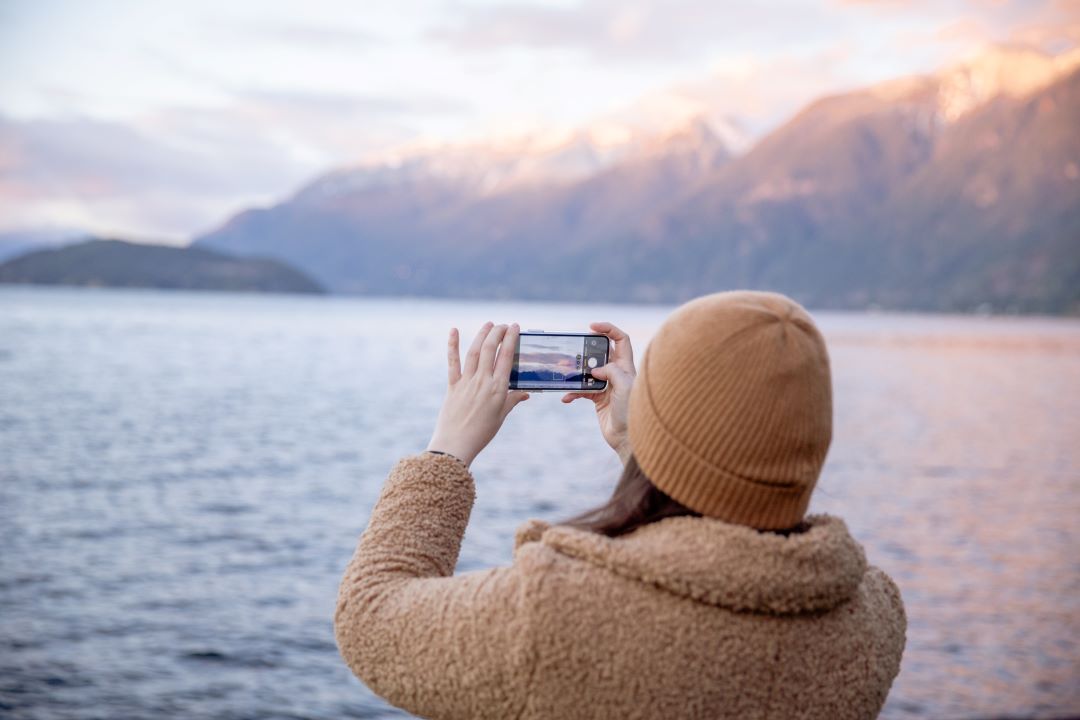 Frau macht ein Bild mit ihrem refurbed Smartphone