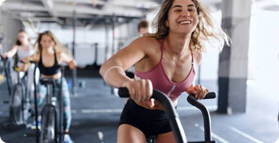 Kvinde cykler på en motionscykel i et fitnesscenter