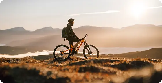 Cyklist på en bjergsti ved solopgang