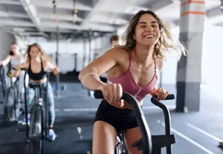 Kvinde træner med refurbished fitnessudstyr