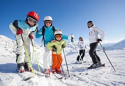 Gruppe i skitøj på et snedækket bjerg